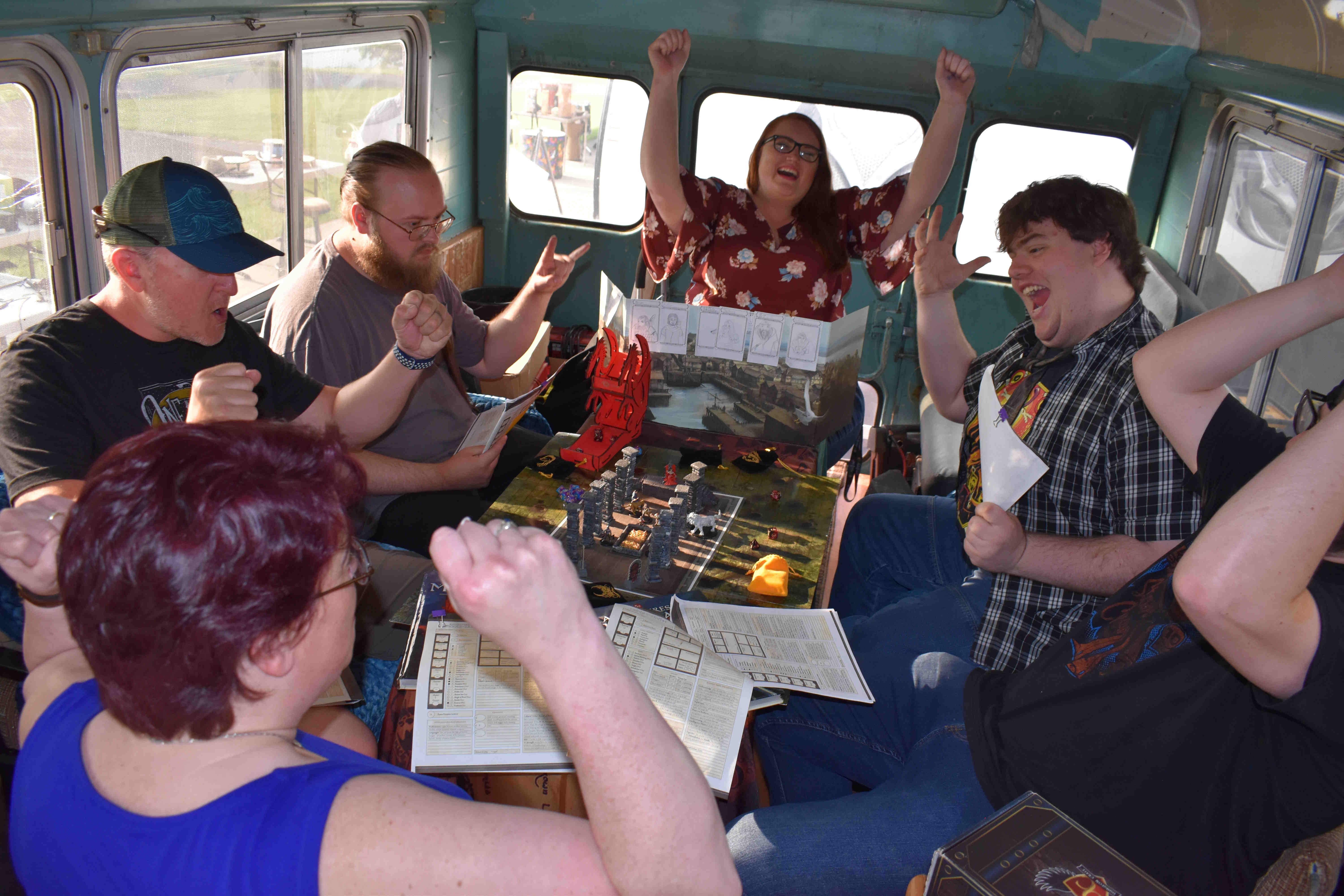Photo of player in our Tabletop Role-Playing Game (TRPG) Program in the Wheelchair Accessible RPG Bus, celebrating a great success!